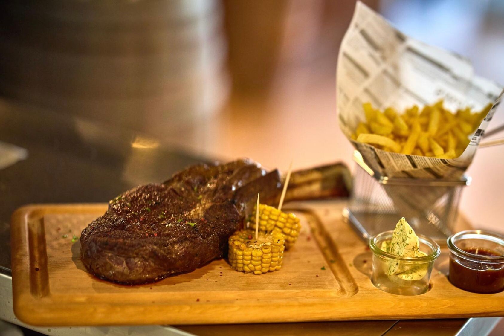 Holzbrett mit gebratenem Steak und Beilagen